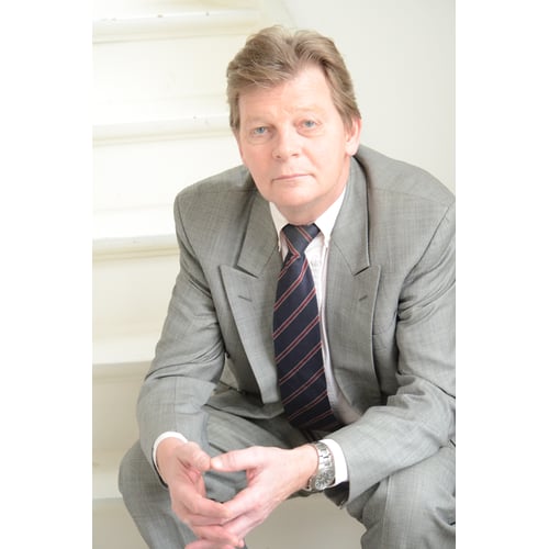 Dutch Actor Peter Rene as a CEO in Chique Suit, Sitting on a Staircase looking into the Lens