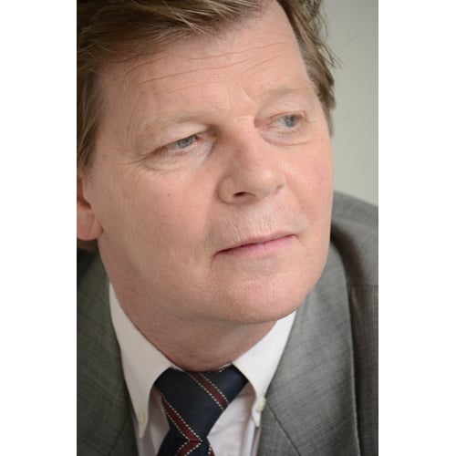 Dutch Actor Peter Rene as a CEO in Chique Suit, Sitting on a Staircase looking Sideways