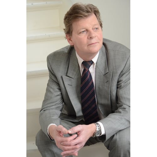 Dutch Actor Peter Rene as a CEO in Chique Suit, Sitting on a Staircase Looking Sideways