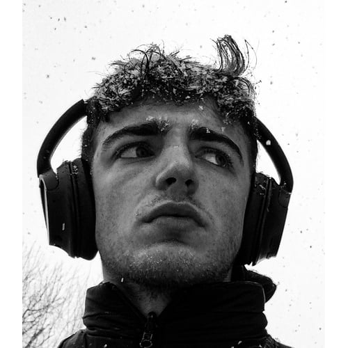 A black and white serious headhsot in the snow